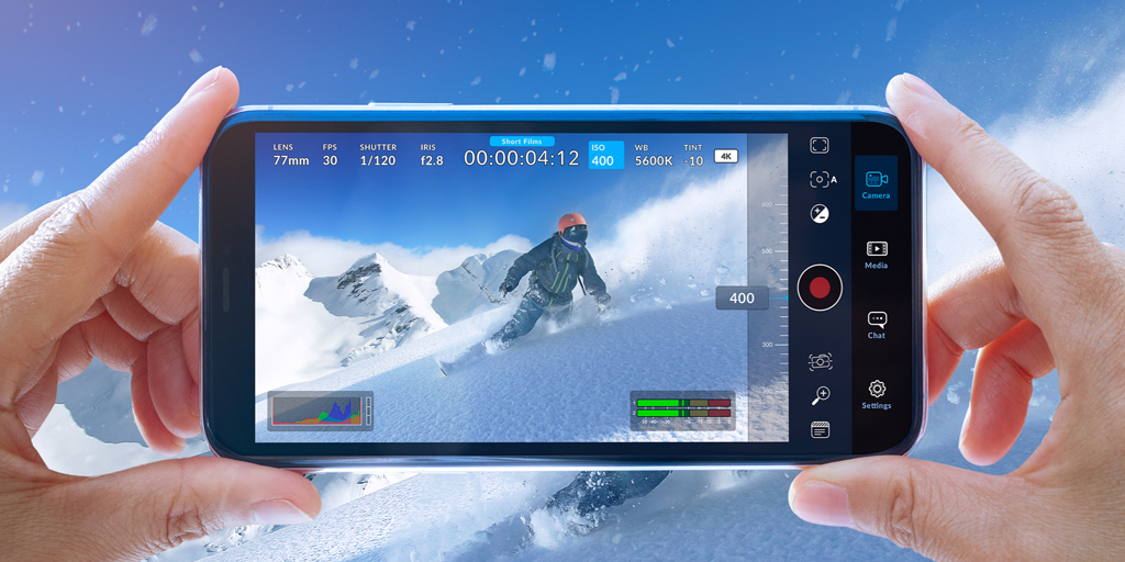 Blackmagic Cameraの撮影画面を表示したスマートフォンと雪山のスキーヤー