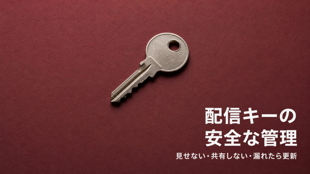 えんじ色の背景に金属の鍵を置き、配信キーの安全な管理を表したイメージ