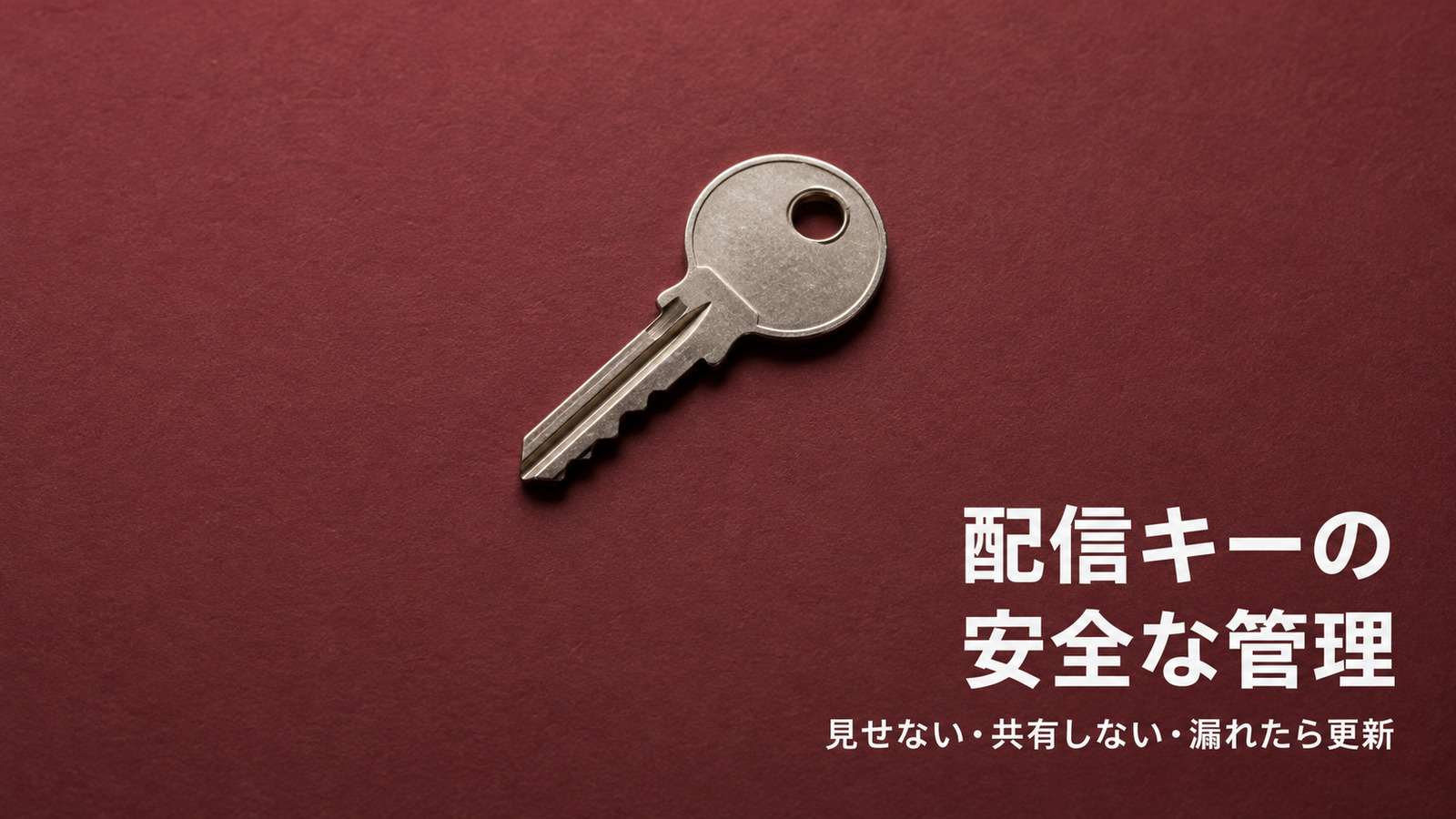 えんじ色の背景に金属の鍵を置き、配信キーの安全な管理を表したイメージ